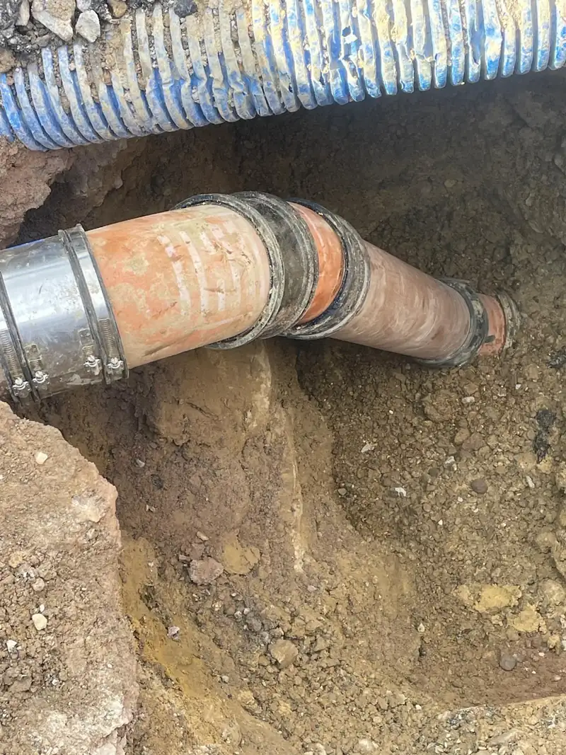 A drainage pipe repair using a collar in an excavated trench