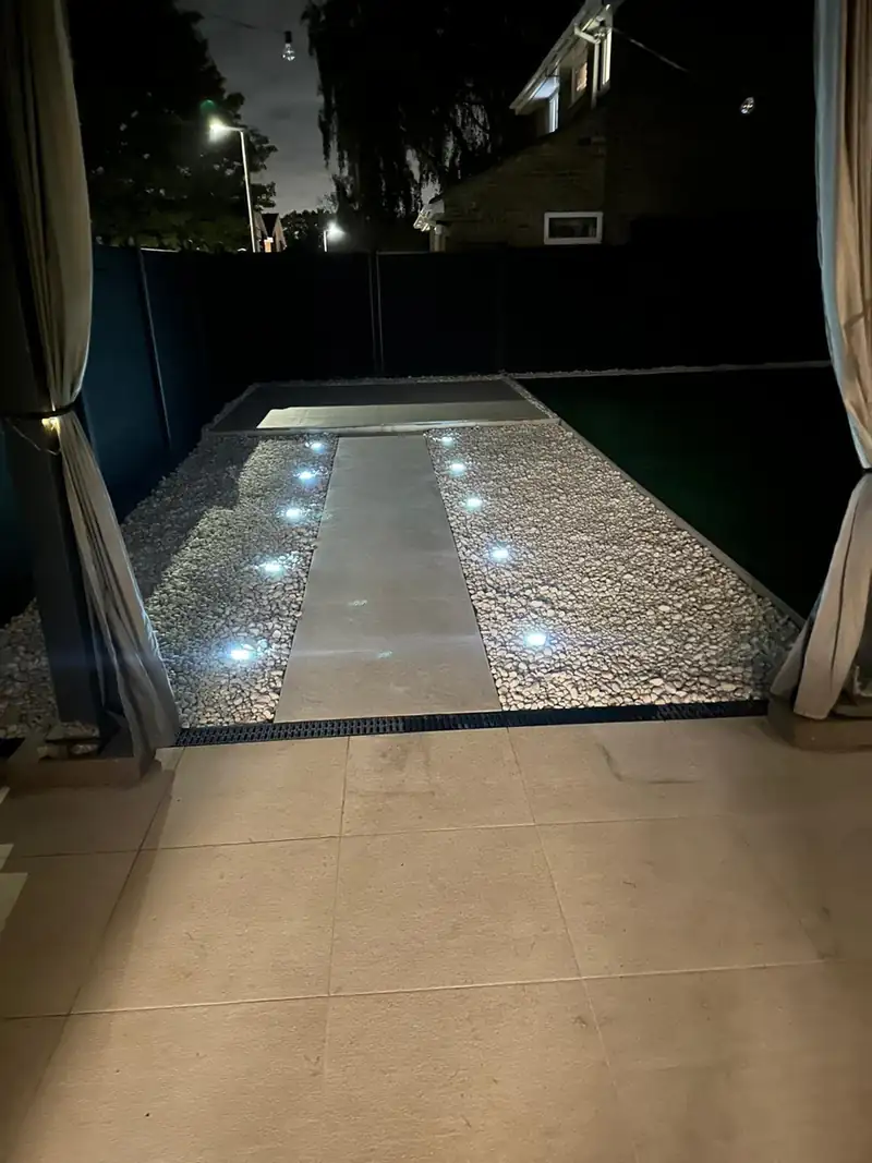 Porcelain path with ground lights set in white gravel at night