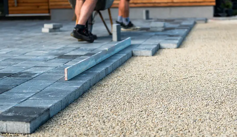 Block paving being laid onto a bed of sand