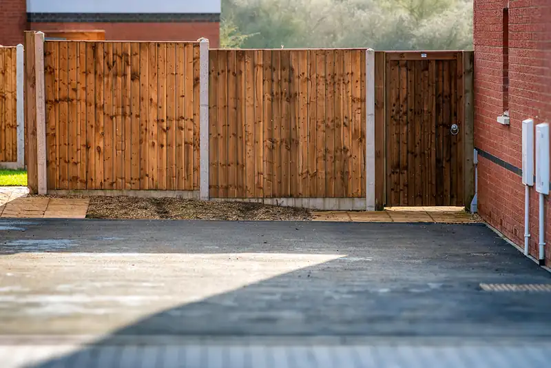 Timber closeboard fence and gate beside a tarmac drive